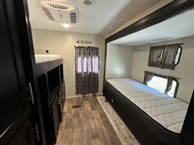 a living room with stainless steel appliances furniture and a kitchen view