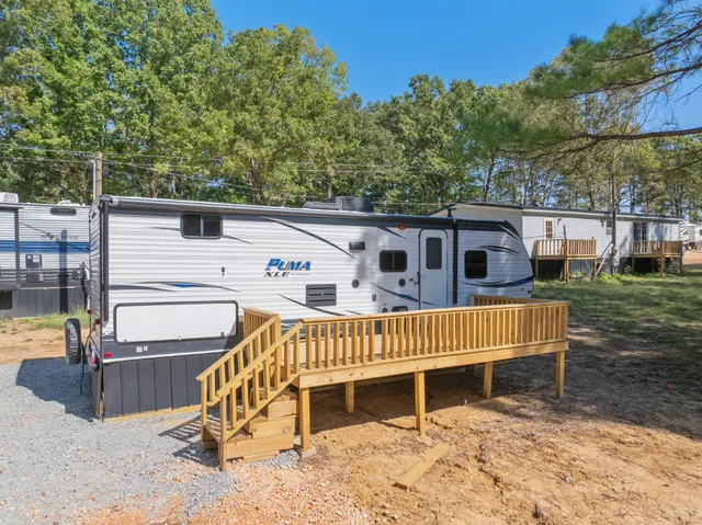 a white house covered with tall trees