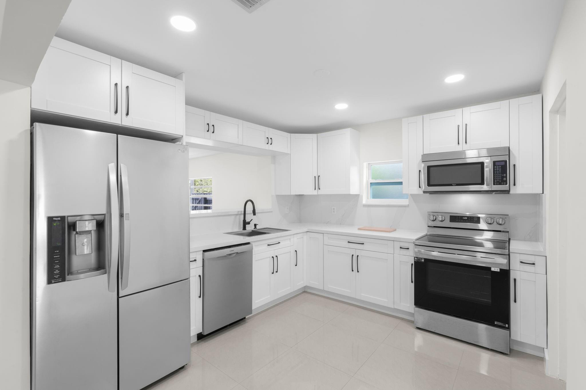 3262 Pierce Street Hollywood, FL 33021 - Photo 12 of 35 a kitchen with stainless steel appliances granite countertop white cabinets a sink a stove a refrigerator and white cabinets