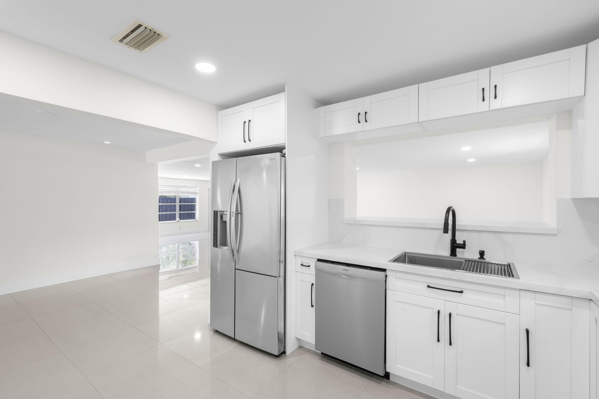 3262 Pierce Street Hollywood, FL 33021 - Photo 13 of 35 a kitchen with white cabinets and stainless steel appliances