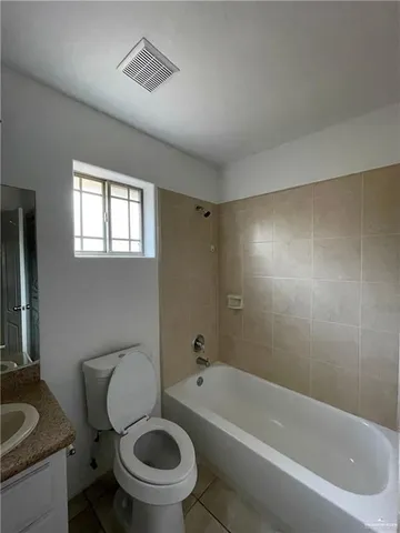 a white toilet sitting next to a bath tub