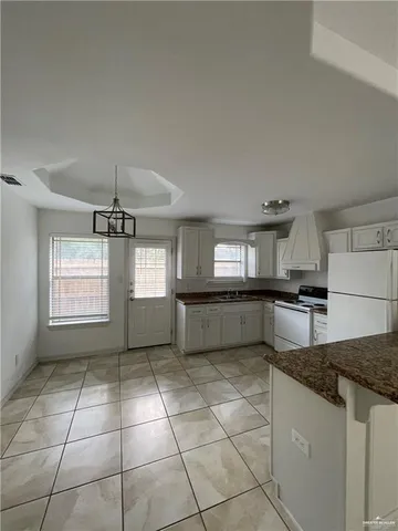 a kitchen with stainless steel appliances granite countertop a sink a stove a microwave and a counter top space