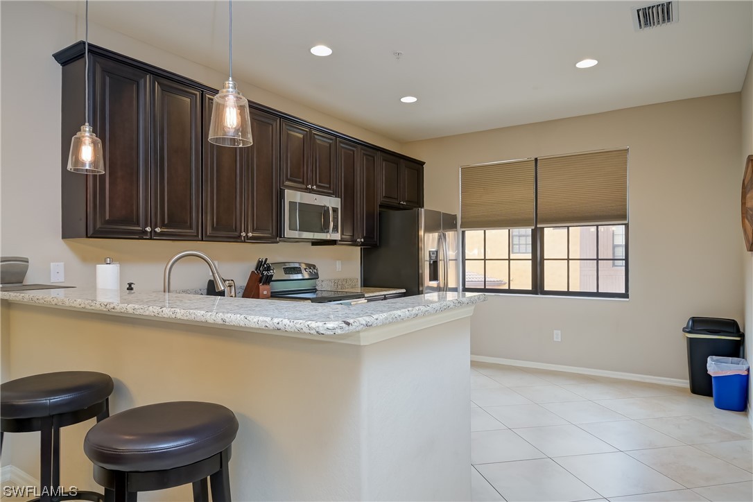 a kitchen with stainless steel appliances granite countertop a sink a stove a microwave a counter space and cabinets