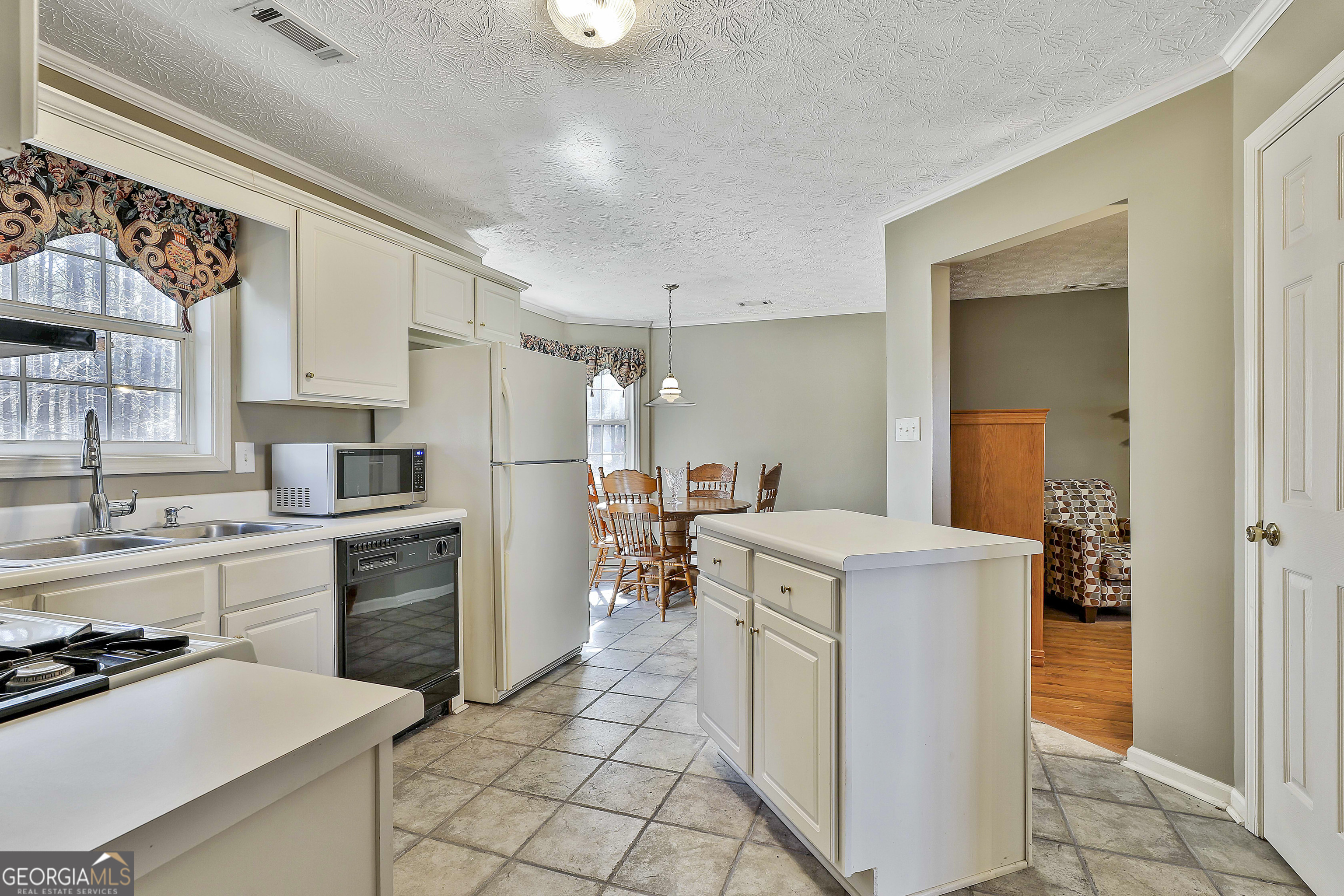 809 Lora Smith Road Newnan, GA 30265 - Photo 17 of 40 a kitchen with a stove a refrigerator and a sink
