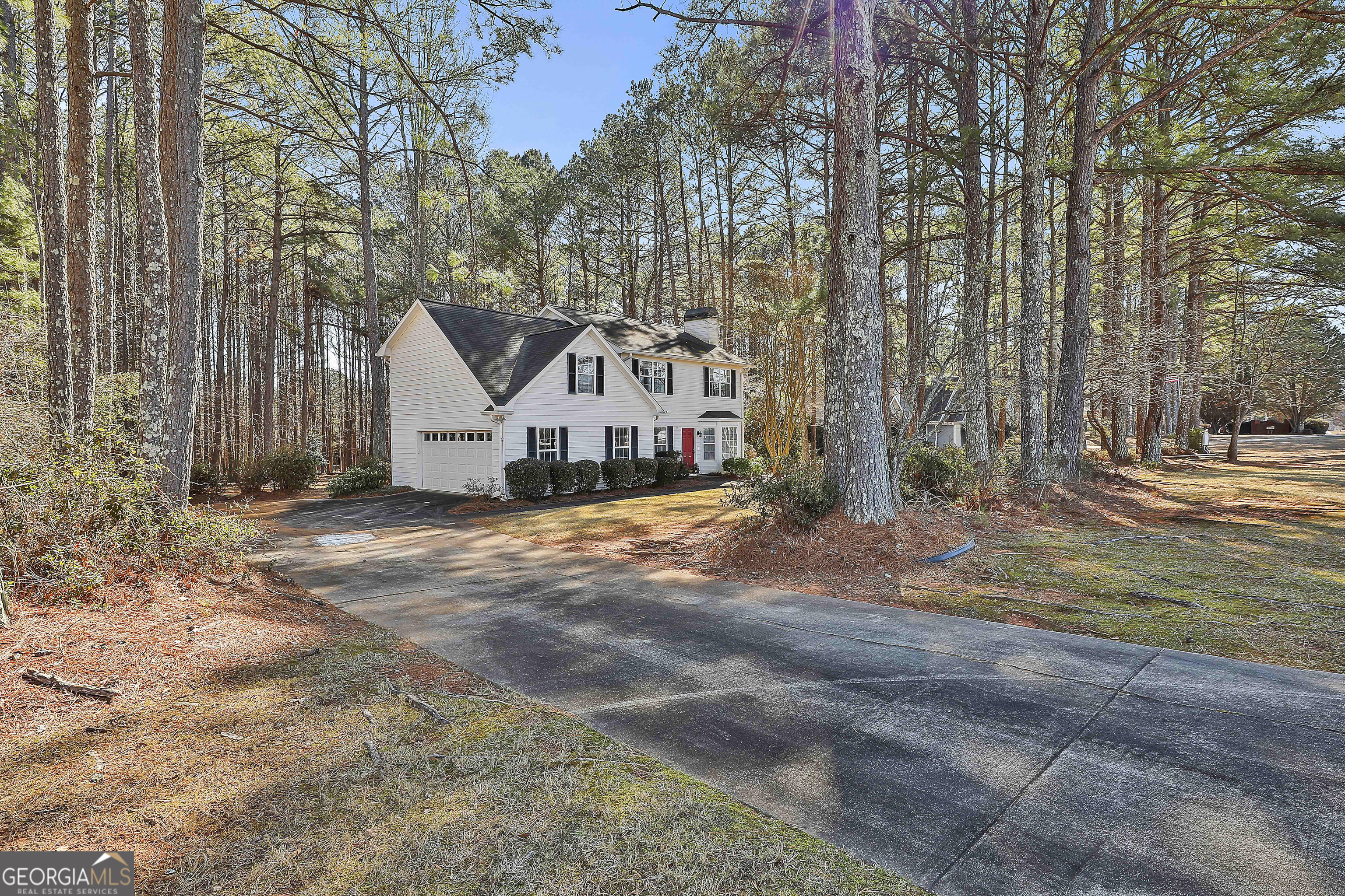 809 Lora Smith Road Newnan, GA 30265 - Photo 2 of 40 a view of a white house with a yard covered with snow and trees