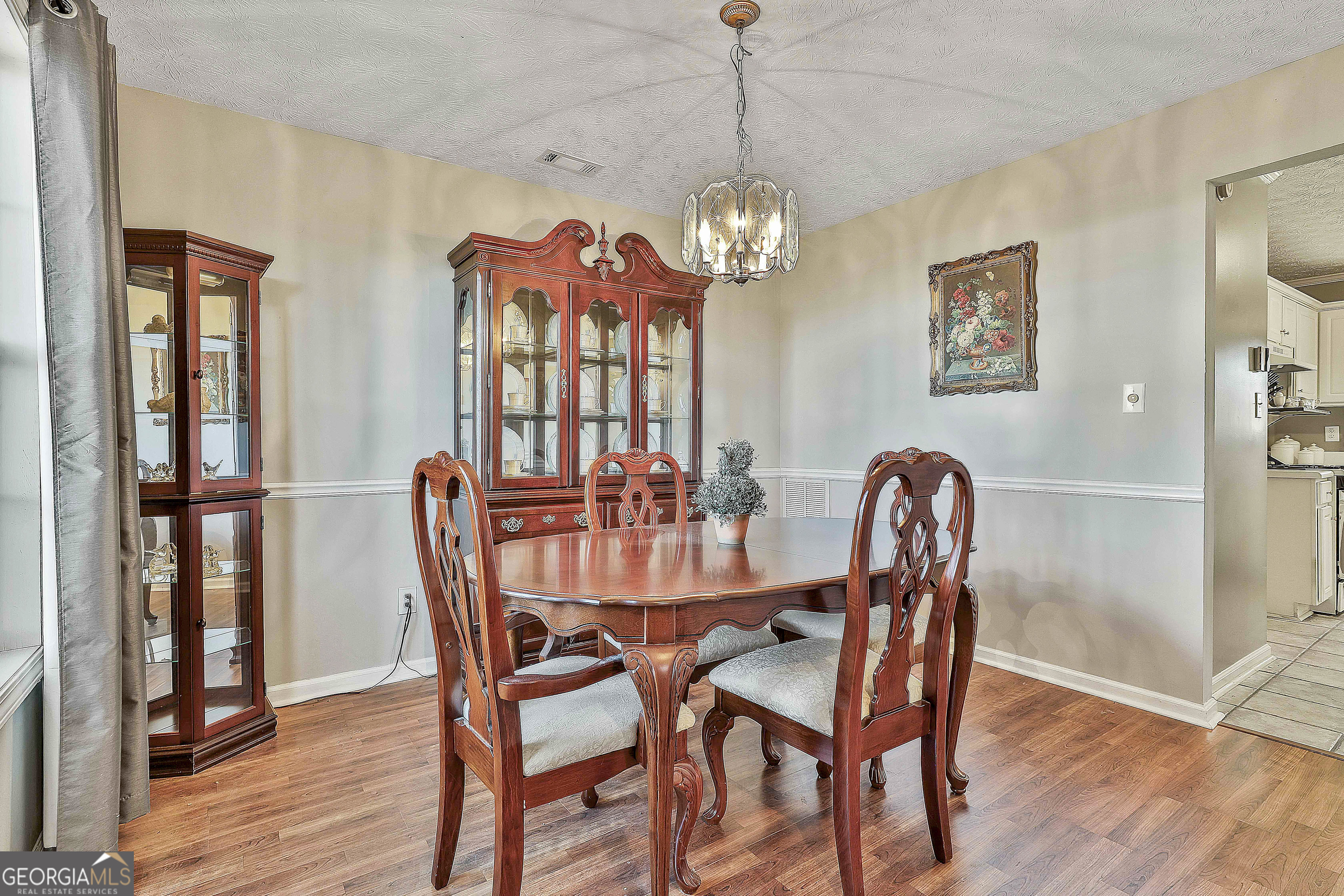 809 Lora Smith Road Newnan, GA 30265 - Photo 22 of 40 a view of a dining room with furniture wooden floor and a chandelier
