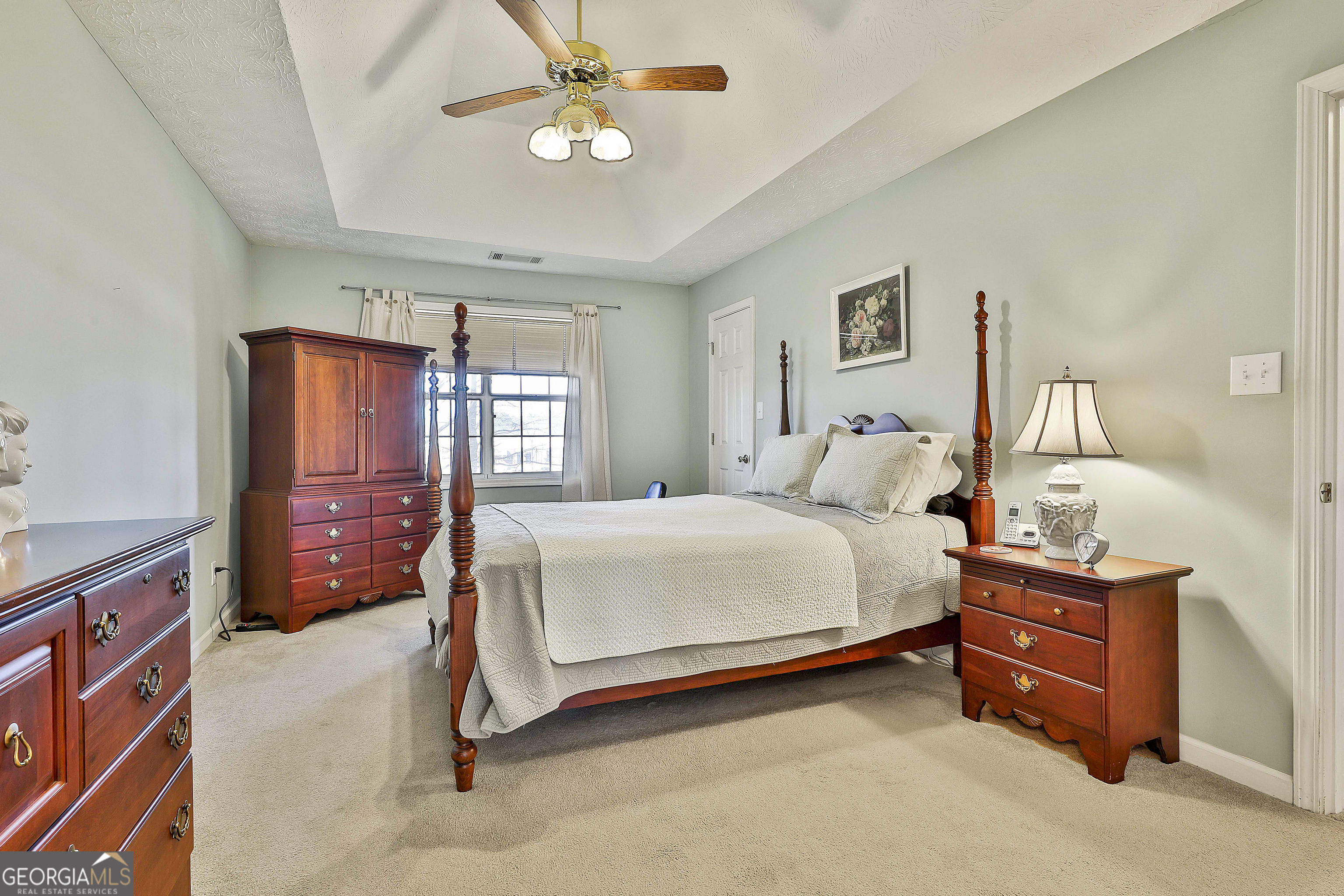 809 Lora Smith Road Newnan, GA 30265 - Photo 26 of 40 a spacious bedroom with a bed and a chandelier