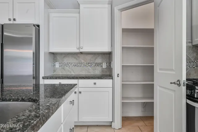 a kitchen with granite countertop a refrigerator and a sink