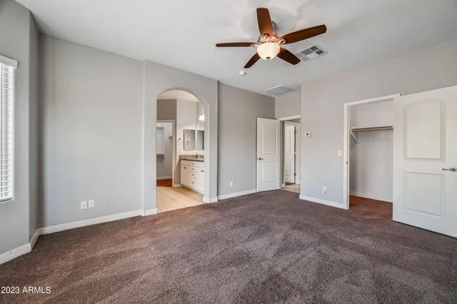 a view of empty room with wooden floor and ceiling fan