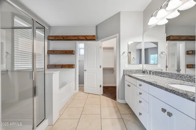 a bathroom with a granite countertop sink a mirror and a shower