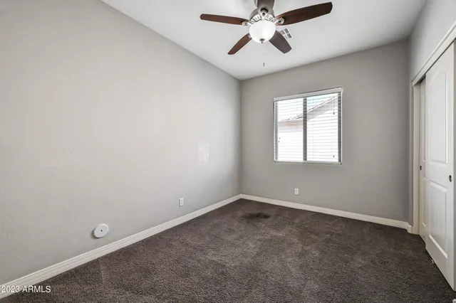 an empty room with windows and fan
