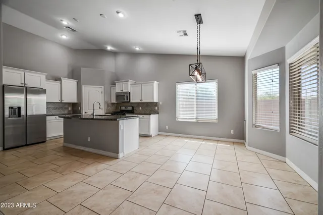 a kitchen with stainless steel appliances granite countertop a stove a sink a refrigerator and cabinets