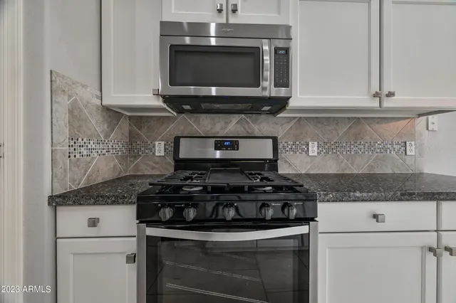 a kitchen with stainless steel appliances granite countertop a stove and a microwave