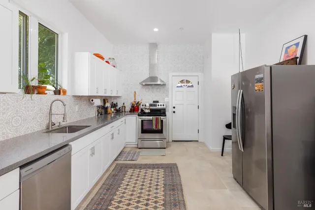 a kitchen with stainless steel appliances a refrigerator sink and cabinets