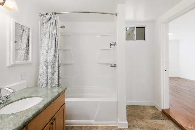 a bathroom with a granite countertop shower sink vanity granite and shower