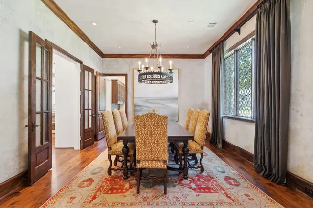 a dining room with furniture a chandelier and wooden floor