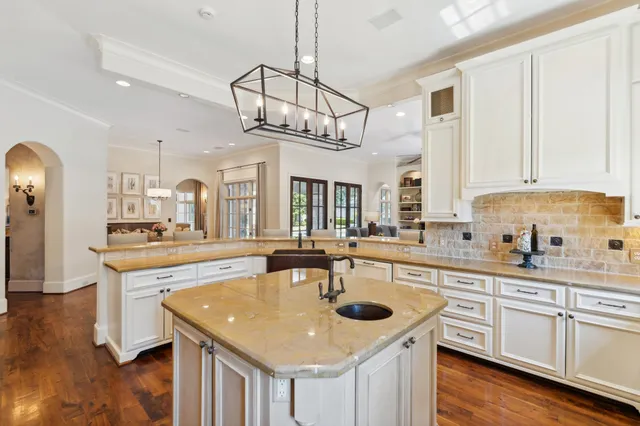 a kitchen with stainless steel appliances granite countertop a sink a stove oven a counter space and cabinets