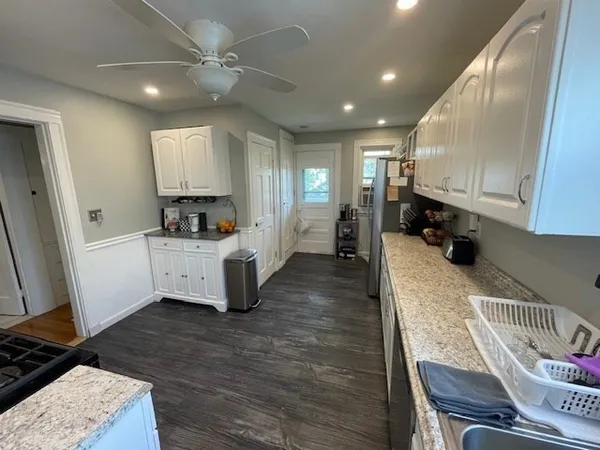 a view of kitchen with sink microwave and cabinets