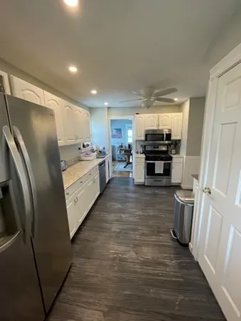 a kitchen with refrigerator and cabinets