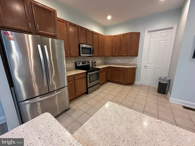 a kitchen with granite countertop a refrigerator and a sink