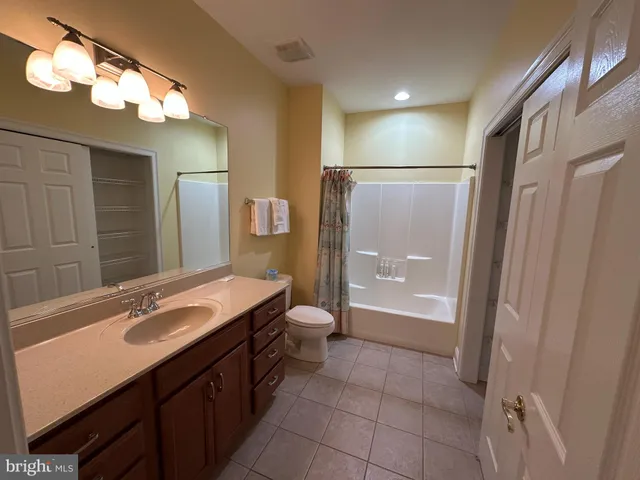 a bathroom with a sink a toilet a mirror and shower