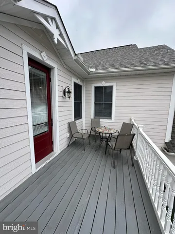 a view of a deck with table and chairs with wooden floor and fence