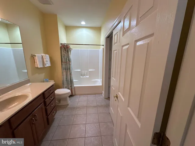 a bathroom with a granite countertop sink a toilet a mirror and shower