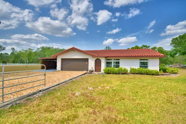 a backyard of a house with table and chairs