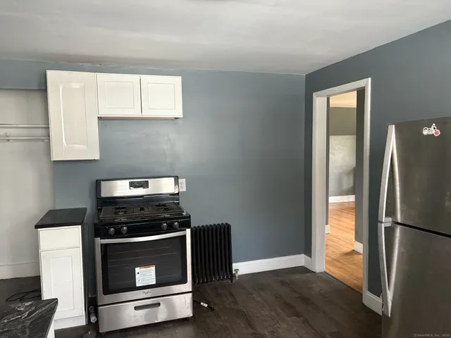 a kitchen with a refrigerator stove and white cabinets
