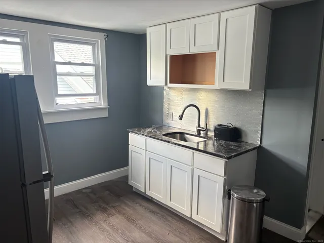 a kitchen with stainless steel appliances a sink a stove cabinets and a window