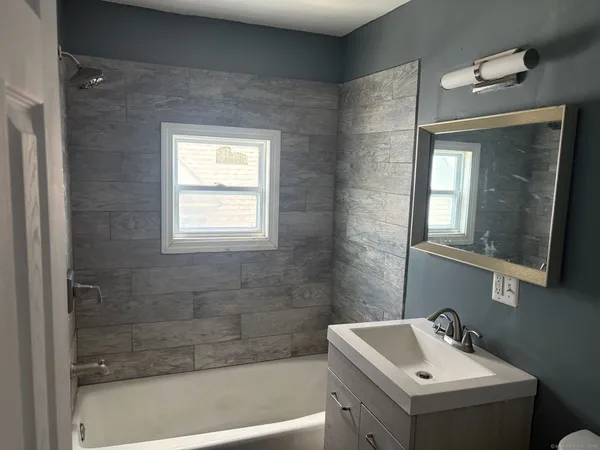 a bathroom with a sink a mirror and a bathtub