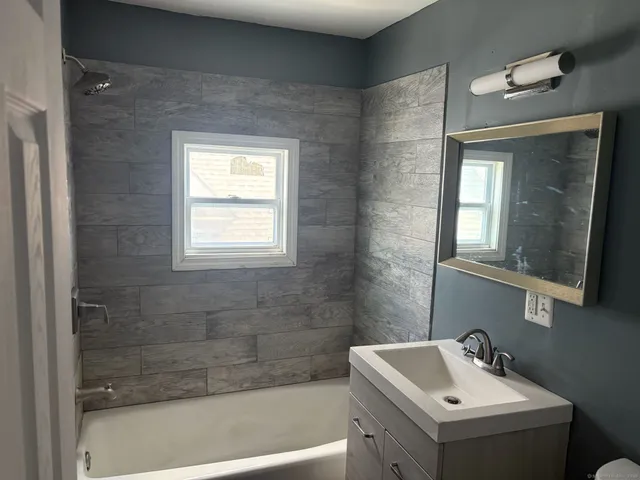 a bathroom with a sink a mirror and a bathtub