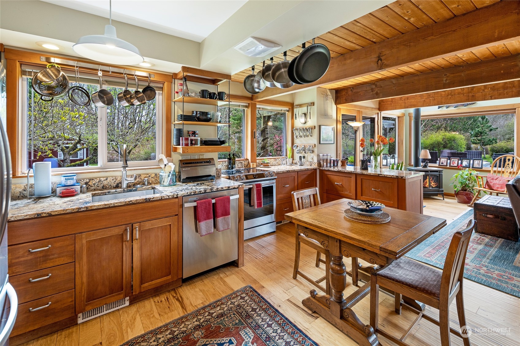 4484 Cattle Point Road Friday Harbor, WA 98250 - Photo 10 of 22 a open kitchen with stainless steel appliances granite countertop a stove a sink and a dining table with garden view