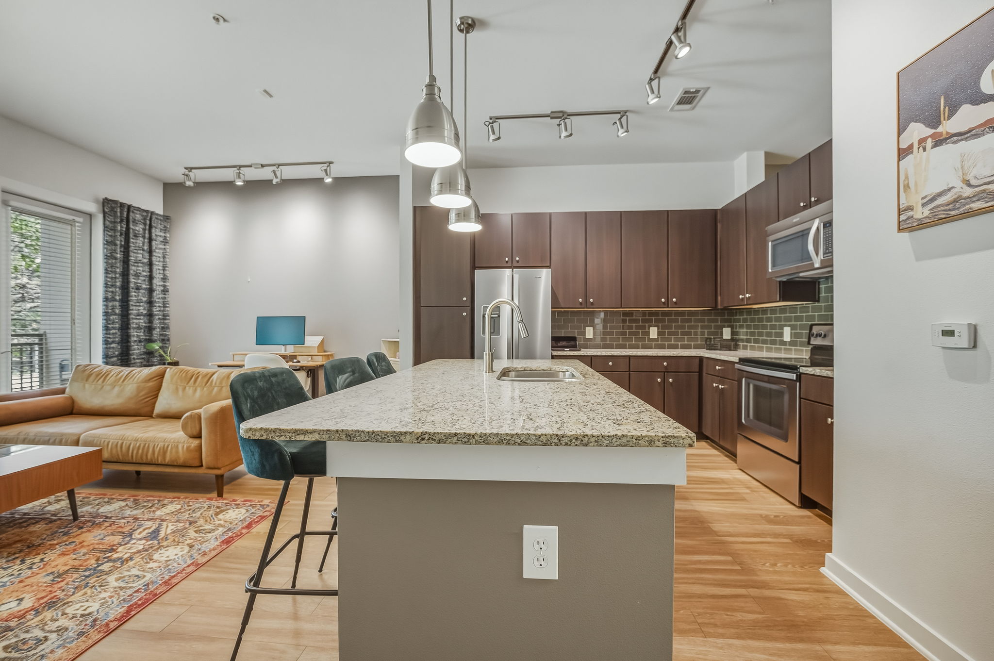 1900 Barton Springs Road, Unit 2006 Austin, TX 78704 - Photo 26 of 26 a large kitchen with stainless steel appliances kitchen island granite countertop a large kitchen island a stove a sink a refrigerator white cabinets and wooden floor