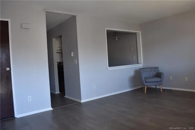 an empty room with a bench and a potted plant