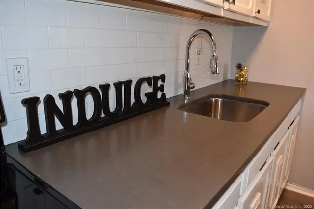 a close view of a sink and dishwasher with kitchen countertops
