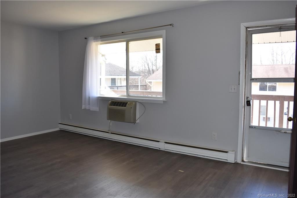 34 Bostwick Arms, Unit 34 New Milford, CT 06776 - Photo 10 of 11 an empty room with wooden floor and windows