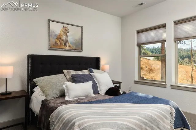 a bedroom with a bed and a painting on the wall