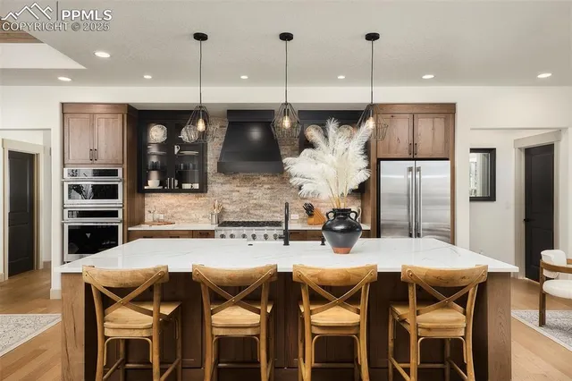 a kitchen with stainless steel appliances kitchen island granite countertop a table and chairs