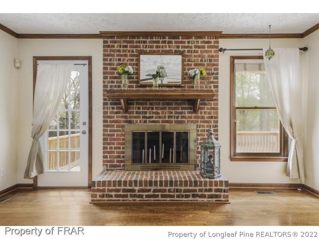 7811 Shuttle Road Fayetteville, NC 28311 - Photo 11 of 36 a living room with a fireplace and wooden floor
