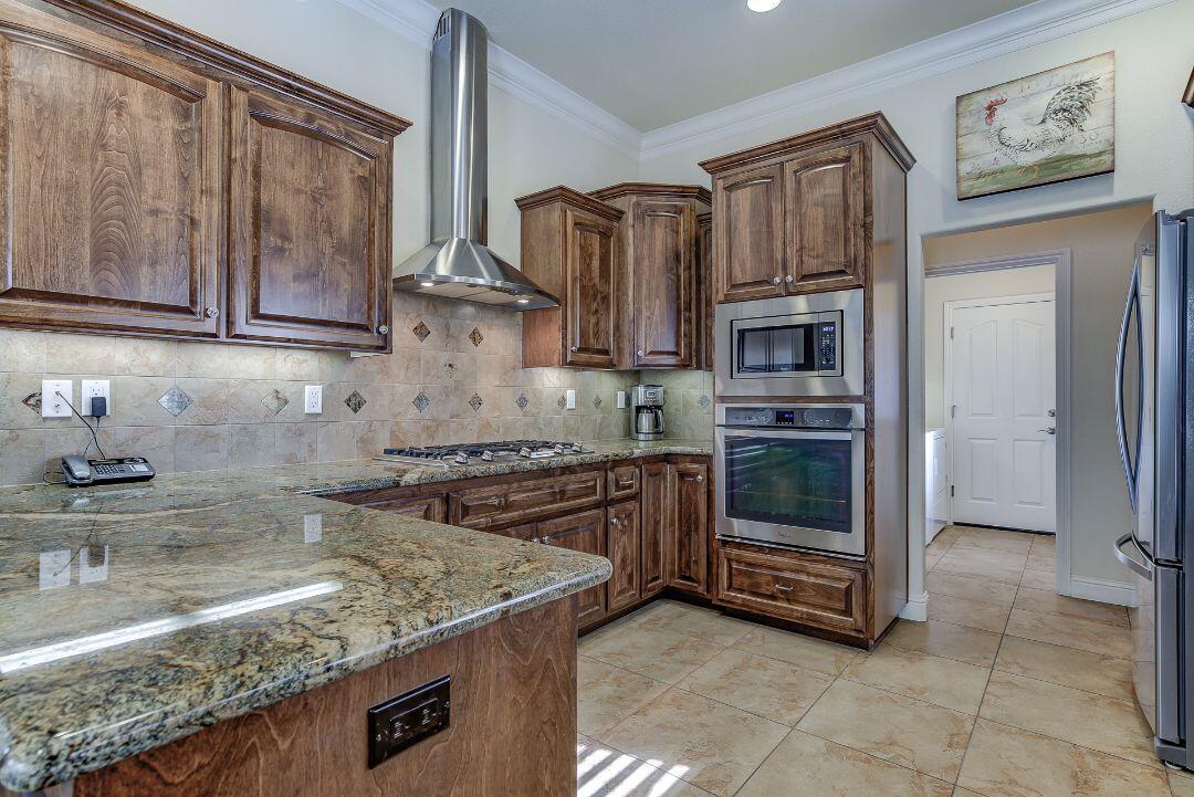 380 Franciscan Trail Redding, CA 96003 - Photo 17 of 78 a kitchen with stainless steel appliances granite countertop a stove a sink and a microwave