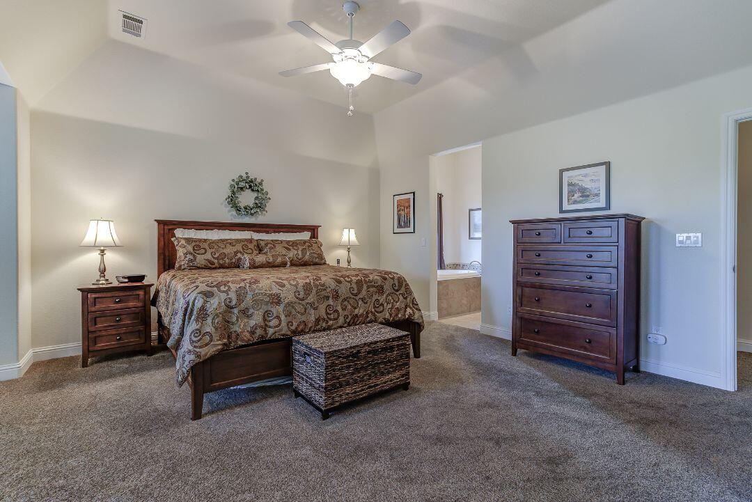 380 Franciscan Trail Redding, CA 96003 - Photo 27 of 78 a bedroom with a bed and a chandelier