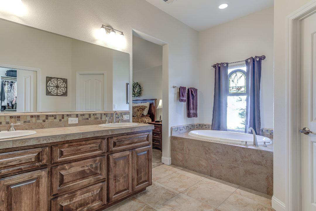 380 Franciscan Trail Redding, CA 96003 - Photo 33 of 78 a spacious bathroom with a tub double sink window and mirror