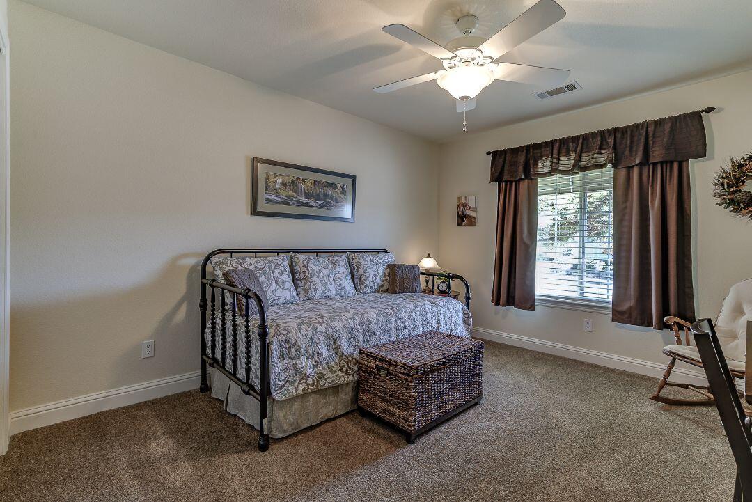 380 Franciscan Trail Redding, CA 96003 - Photo 36 of 78 a spacious bedroom with a bed and a chandelier