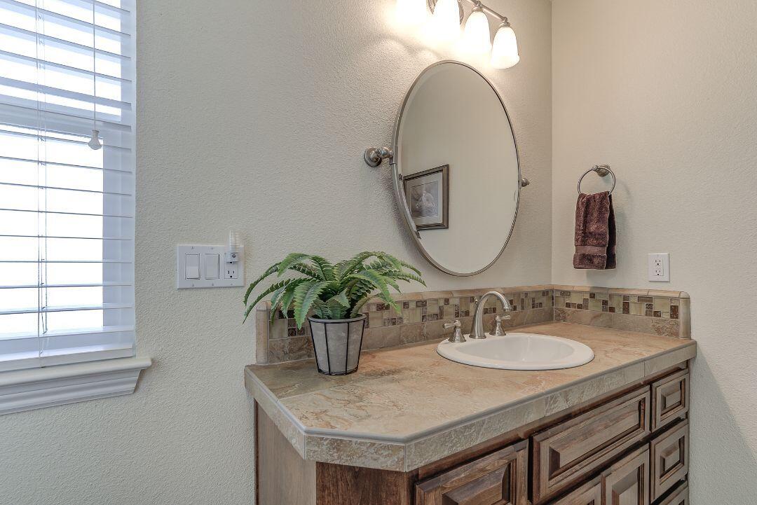 380 Franciscan Trail Redding, CA 96003 - Photo 40 of 78 a bathroom with a granite countertop sink a mirror and a window