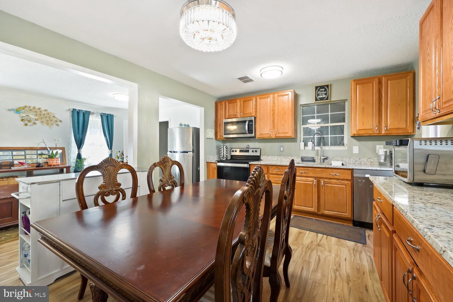 9463 Rogues Road Midland, VA 22728 - Photo 15 of 35 a kitchen with stainless steel appliances granite countertop a stove top oven a sink a dining table and chairs