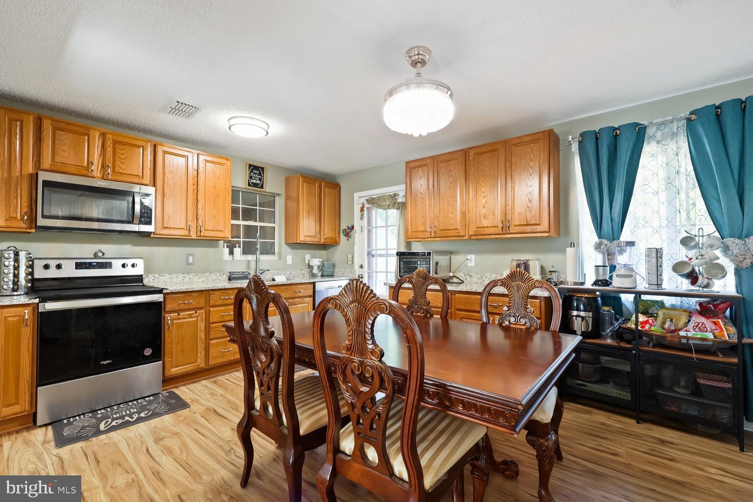 9463 Rogues Road Midland, VA 22728 - Photo 16 of 35 a kitchen with granite countertop a stove a sink a dining table and chairs