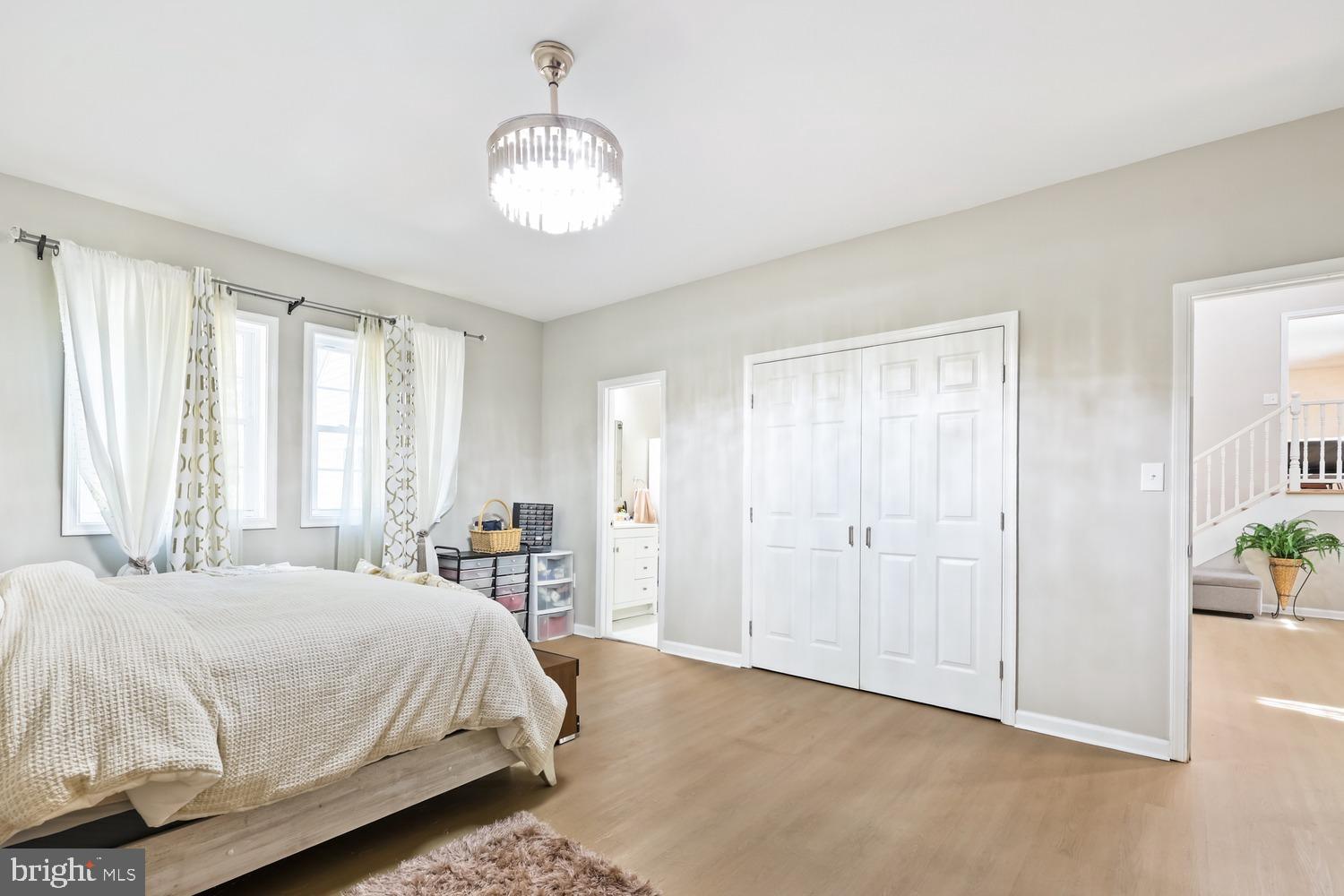 9463 Rogues Road Midland, VA 22728 - Photo 17 of 35 a spacious bedroom with a bed and a chandelier
