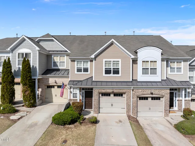 a view of a big house with a small yard and plants