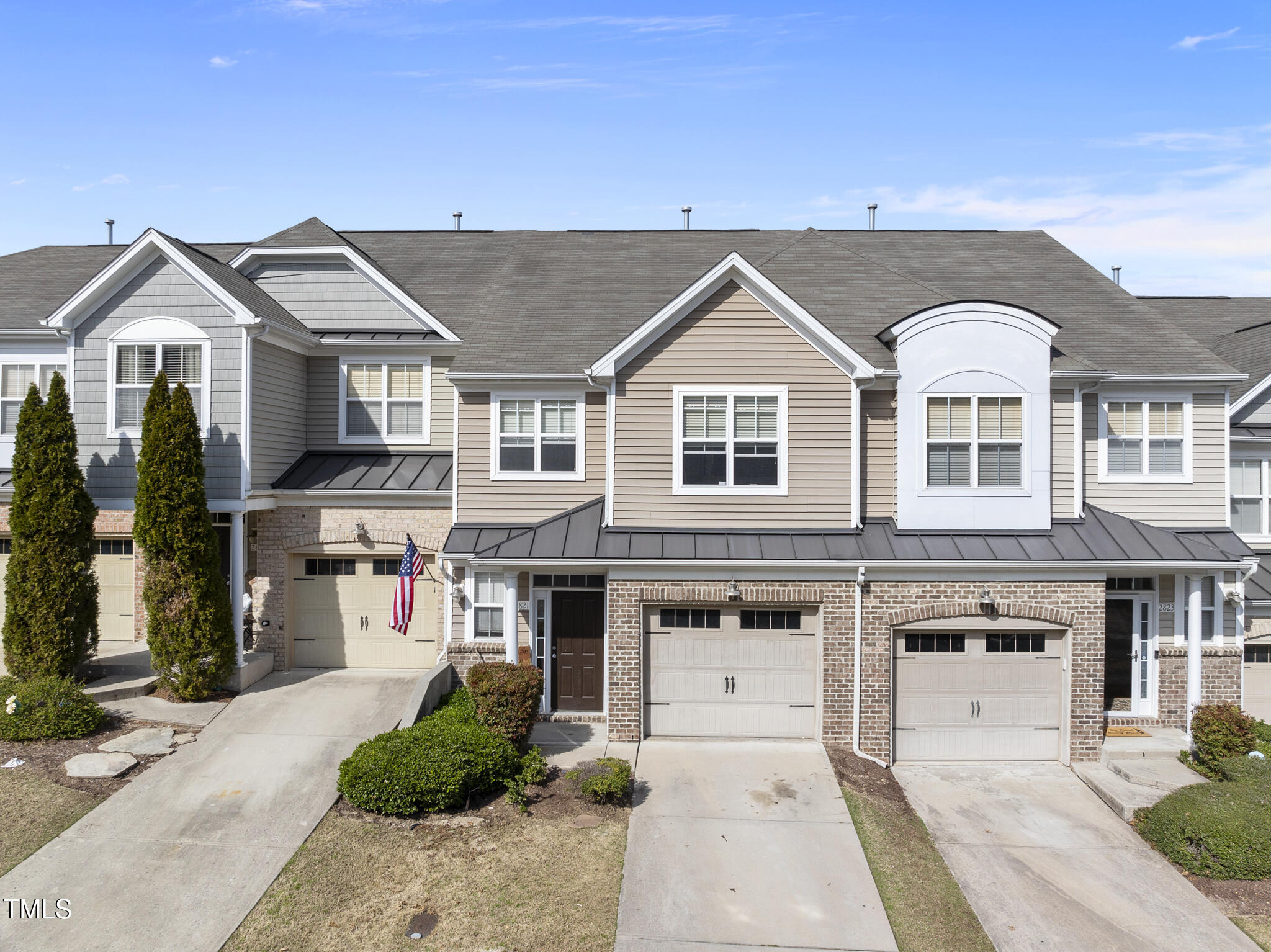 a view of a big house with a small yard and plants